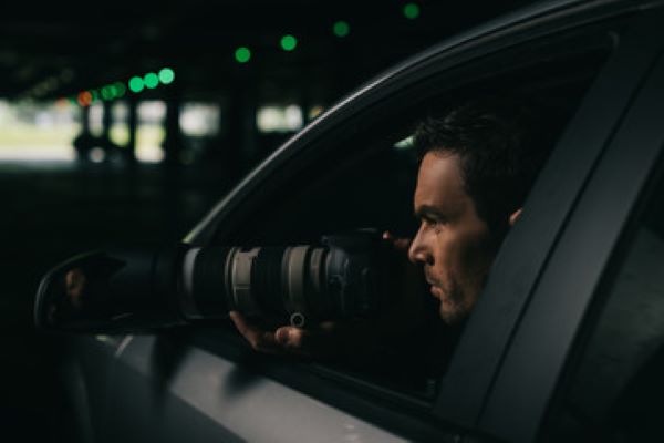 investigadores privados cdmx: Hombre en un carro oscuro tomando fotografías