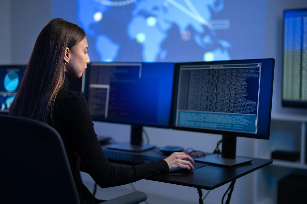 Una mujer revisa datos en su computadora, enfocada en una investigación digital en un ambiente de oficina.